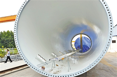 8月17日下午,工作人员从巨大的风筒前走过.